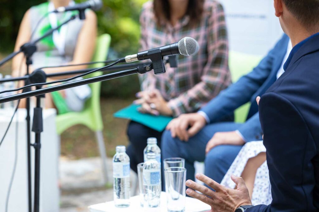 Table ronde professionnelle en extérieur avec micros et intervenants